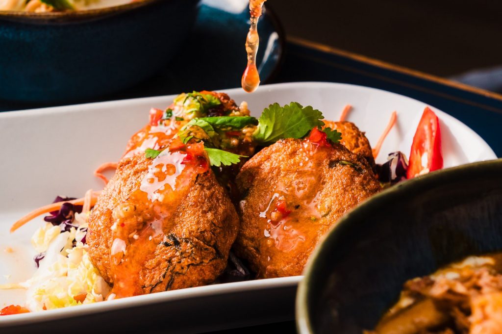 Thai fishcakes being drizzled with sweet chilli sauce